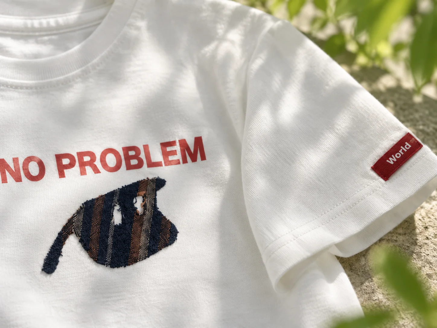 Close-up of the upcycled sloth motif and red sleeve label
